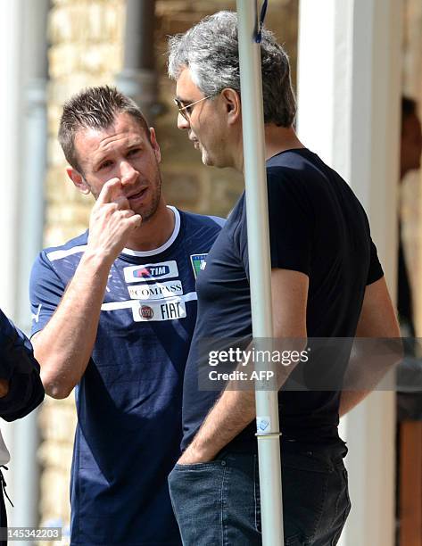 Italian singer Andrea Bocelli speaks with player Antonio Cassano a national football team training session in Firenze on May 27, 2012. AFP...