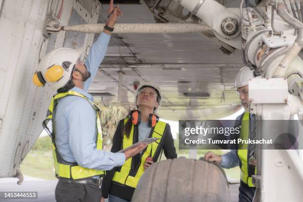 engineers repairing and maintaining  on jet engine airplane . - airport asian worker stock-fotos und bilder