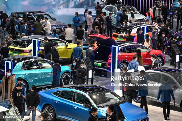 Visitors look at electric vehicles at the Volkswagen stand during the 20th Guangzhou International Automobile Exhibition at Canton Fair Complex on...