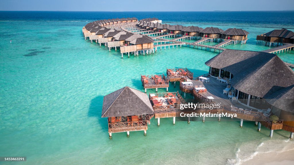 Malediven Island Overwater Villa Bungalows im türkisfarbenen Hotel Resort Lagune mit Luftbild