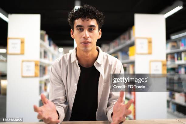 young student doing a video call in the library at university - virtual library stock pictures, royalty-free photos & images