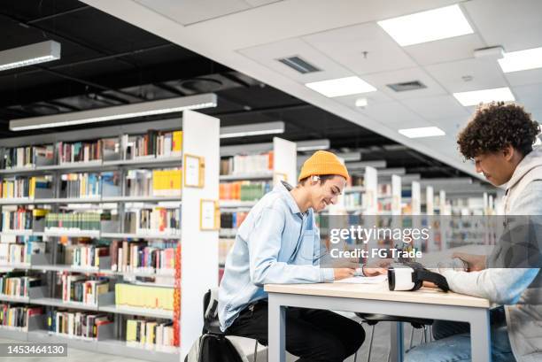 young students studying at university library - library stock pictures, royalty-free photos & images