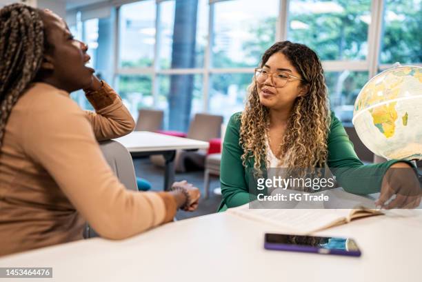 young students women talking in classroom at university - 19 to 22 years and friends and talking stock pictures, royalty-free photos & images