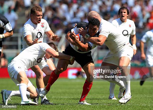 Mils Muliaina of The Barbarians is wrapped up by the England defence during the Killik Cup match between England and The Barbarians at Twickenham...