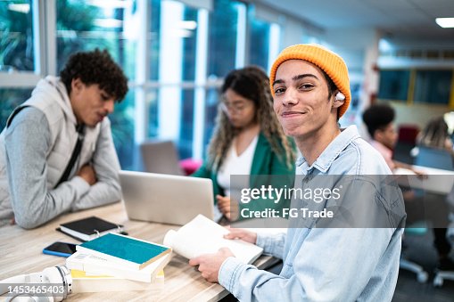 Portrait of a young student man while his friends talk in the background at university/school Portrait of a young student man while his friends talk in the background at university/school