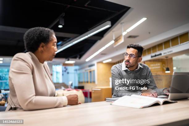 teacher talking and giving assistance to university student at university - giving feedback stock pictures, royalty-free photos & images