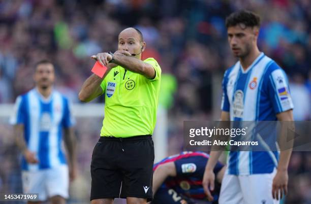 Referee Antonio Mateu Lahoz prepares to award a red card to Vinicius Souza of RCD Espanyol during the LaLiga Santander match between FC Barcelona and...
