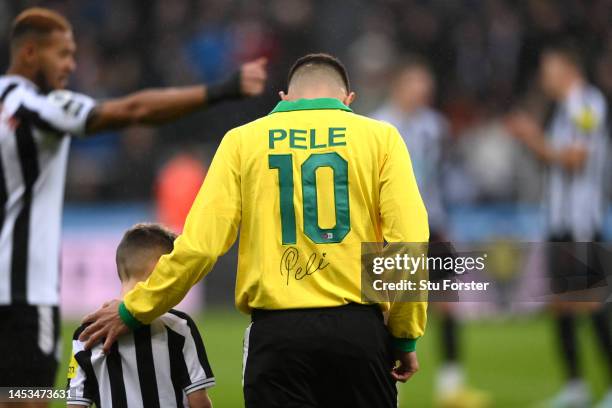 Bruno Guimaraes of Newcastle United walks onto the pitch, whilst wearing a signed Pele 10 shirt, prior to the Premier League match between Newcastle...