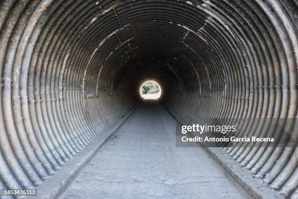 passable drain in the form of a tunnel under the highway - deep hole stock pictures, royalty-free photos & images