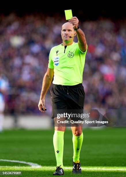 Antonio Mateu Lahoz, match referee shows a yellow card during the LaLiga Santander match between FC Barcelona and RCD Espanyol at Spotify Camp Nou on...