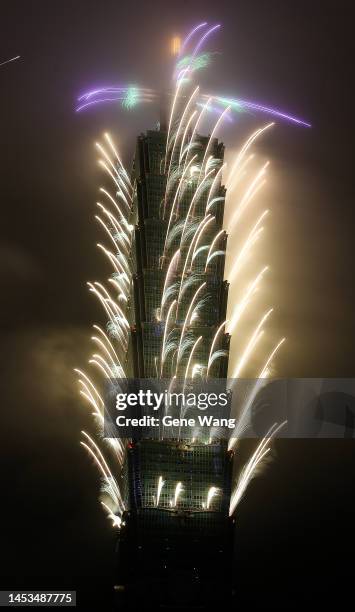 People celebrate as fireworks light up the skyline from the Taipei 101 building during New Year's celebrations on January 01, 2023 in Taipei, Taiwan.