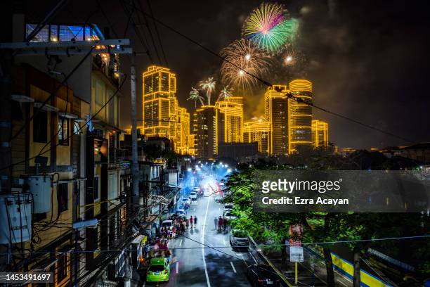 Fireworks explode over buildings during New Year's celebrations on January 01, 2023 in Makati, Metro Manila, Philippines.