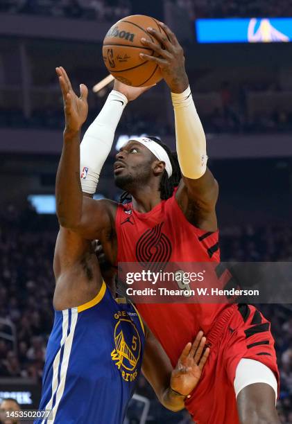 Jerami Grant of the Portland Trail Blazers shoots over Kevon Looney of the Golden State Warriors during the first quarter at Chase Center on December...