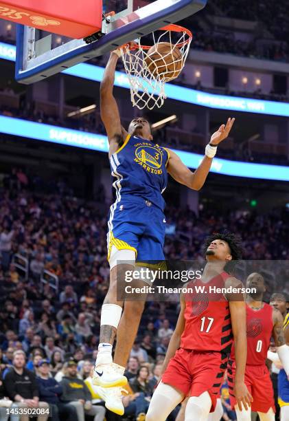 Jordan Poole of the Golden State Warriors goes up for a slam dunk in front of Shaedon Sharpe of the Portland Trail Blazers during the third quarter...