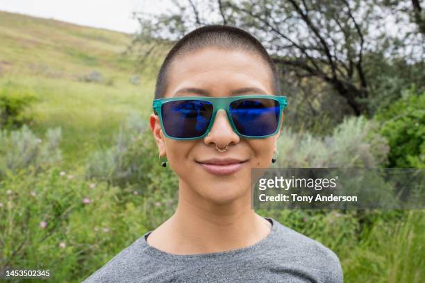 portrait of young woman in sunglasses outdoors - shaved head stock pictures, royalty-free photos & images
