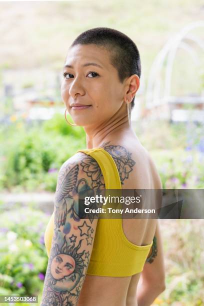 portrait of young woman who has short hair and tattoos - shaved head stock pictures, royalty-free photos & images