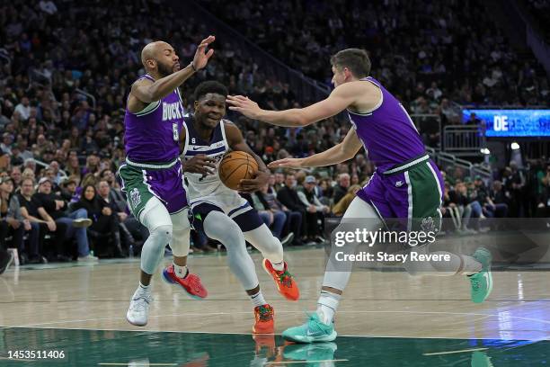 Anthony Edwards of the Minnesota Timberwolves drives between Grayson Allen and Jevon Carter of the Milwaukee Bucks during a game at Fiserv Forum on...