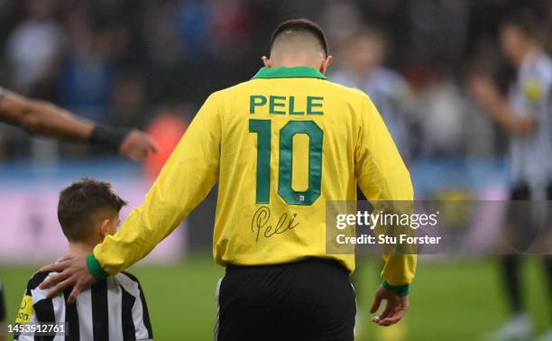 Bruno Guimaraes wears a signed Pele 10 shirt, prior to the teams holding a minutes applause in memory of former Brazil player Pele prior to the...