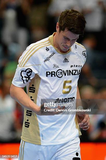 Kim Andersson of Kiel looks at his hand after suffering an injury during the EHF Final Four final match between THW Kiel and BM Atletico Madrid at...