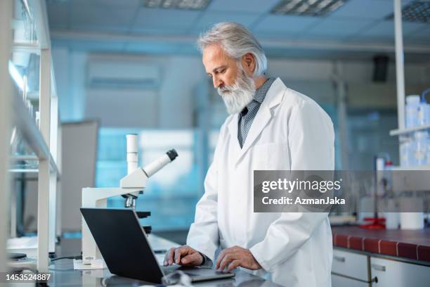 senior professional biochemist noting results of experiment at table - old laboratory stock pictures, royalty-free photos & images