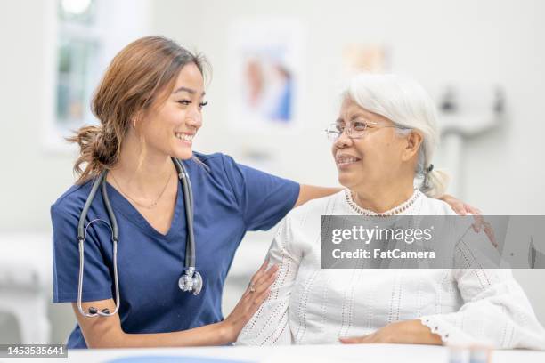 senior woman at the doctors - filipino woman smiling stock pictures, royalty-free photos & images