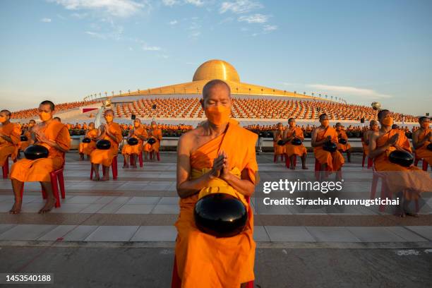 Buddhist monks pray during the mass alms giving ceremony for New Year where 3,000 monks attend at Wat Phra Dhammakaya Buddhist Temple on January 01,...