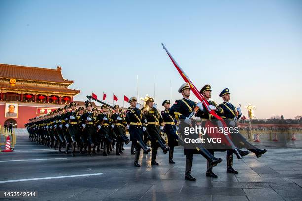 The Guard of Honor of the Chinese People's Liberation Army escorts the national flag during a flag-raising ceremony at the Tian'anmen Square to...