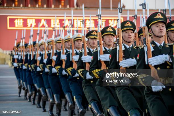 The Guard of Honor of the Chinese People's Liberation Army escorts the national flag during a flag-raising ceremony at the Tian'anmen Square to...