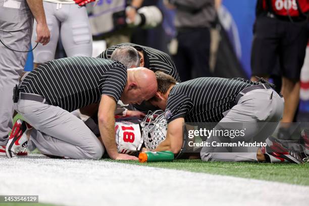 Marvin Harrison Jr. #18 of the Ohio State Buckeyes is down on the field after suffering an injury during the third quarter against the Georgia...