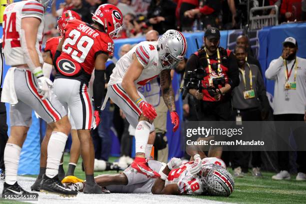 Marvin Harrison Jr. #18 of the Ohio State Buckeyes is down on the field after suffering an injury during the third quarter against the Georgia...
