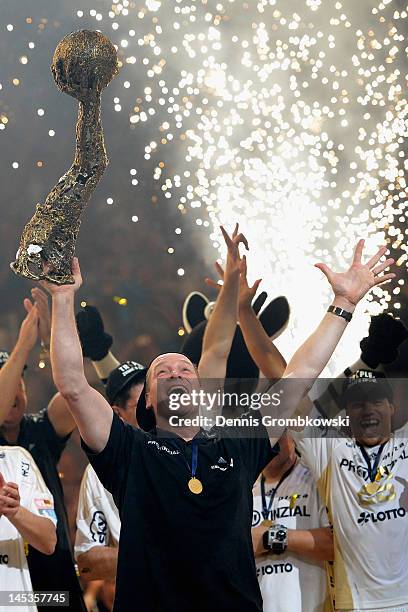 Head coach Alfred Gislason of Kiel celebrates with the trophy after the EHF Final Four final match between THW Kiel and BM Atletico Madrid at Lanxess...