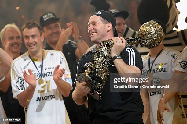 Head coach Alfred Gislason of Kiel celebrates with the trophy after the EHF Final Four final match between THW Kiel and BM Atletico Madrid at Lanxess...