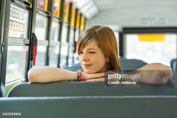 schoolgirl sitting in school bus - kid sitting stock pictures, royalty-free photos & images