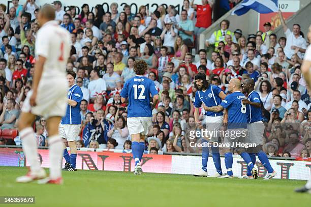 Players congratulate Sergio Pizzorno after he scores at Soccer Aid 2012 in aid of Unicef at Old Trafford on May 27, 2012 in Manchester, England.