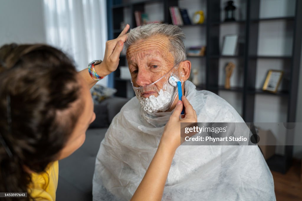 Voluntario en la visita a casa en el hombre de la tercera edad, se preocupa por su higiene