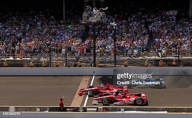 Dario Franchitti of Scotland, driver of the Target Chip Ganassi Racing Honda crosses the yard of bricks start/finish line to take the checkered flag...