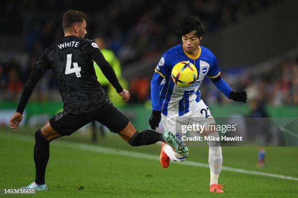 Kaoru Mitoma of Brighton & Hove Albion is challenged by Ben White of Arsenal during the Premier League match between Brighton & Hove Albion and...