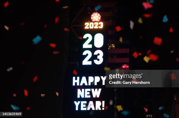 Confetti falls in front of the crystal ball and a Happy New Year sign in Times Square on January 1 in New York City.