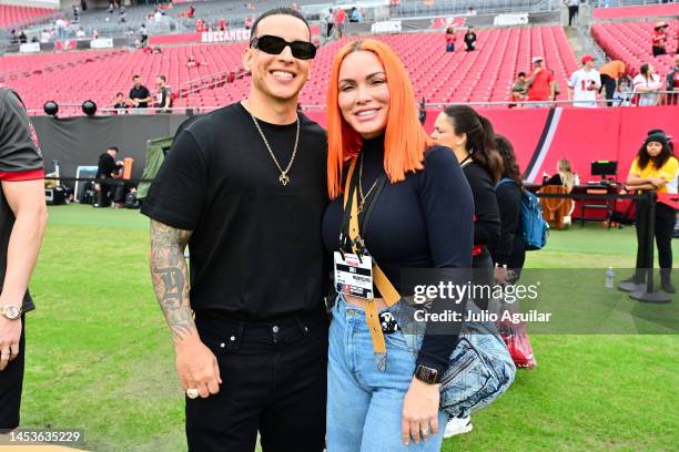 Recording artist Daddy Yankee and his wife Mireddys González pose for a photo on the field before the game between the Tampa Bay Buccaneers and the...