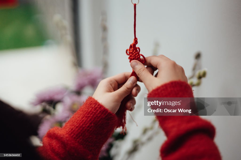 Female hands tying a decorative Chinese Good luck Knot for Chinese New Year