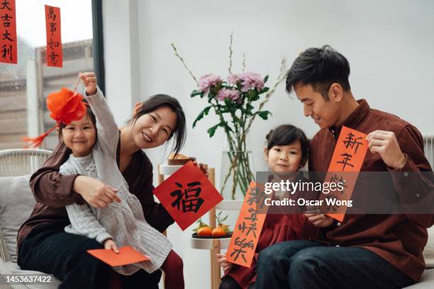 cheerful two-generation asian family portrait for chinese new year - welcome back phrase imagens e fotografias de stock