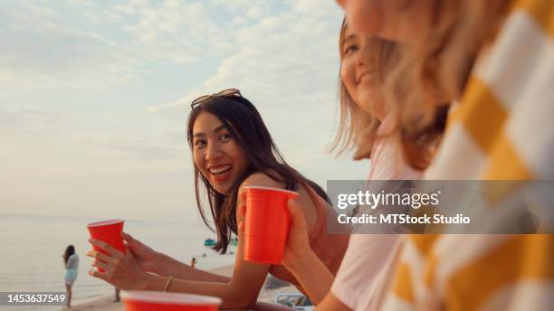 close up group of young asian women celebrating and drinking alcohol on tropical beach. - asian female friends drinking soda outdoor stock pictures, royalty-free photos & images