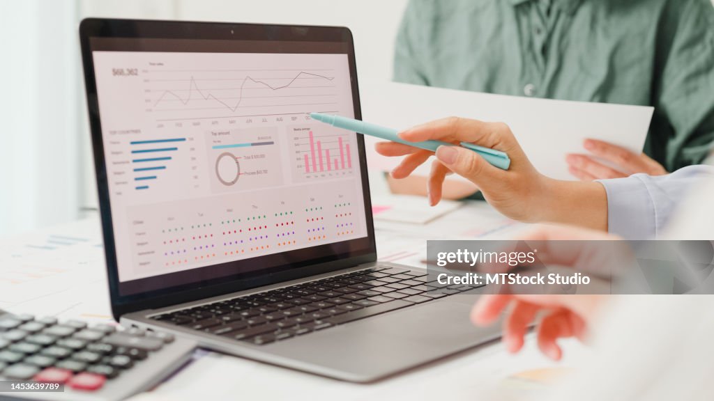 Un grupo de empresarios asiáticos que se reúnen discuten el plan del proyecto y los resultados financieros en la oficina.