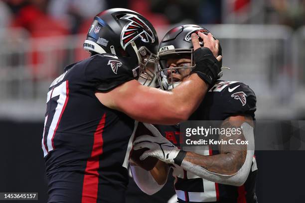 Tyler Allgeier of the Atlanta Falcons celebrates a touchdown with Drew Dalman during the second quarter in the game against the Arizona Cardinals at...