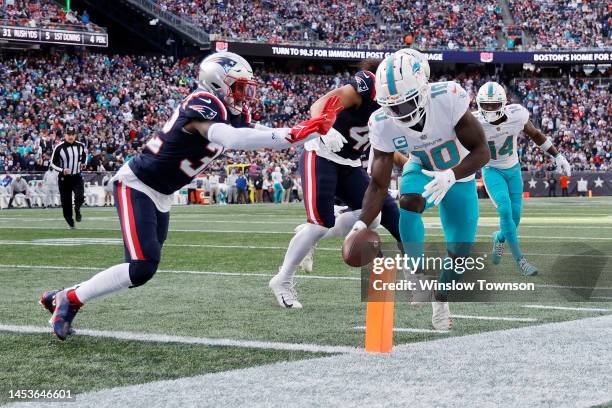 Tyreek Hill of the Miami Dolphins scores a touchdown against Devin McCourty of the New England Patriots during the second quarter at Gillette Stadium...