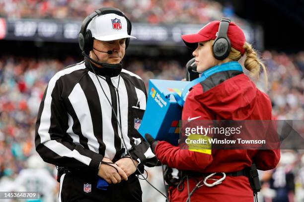 Referee Brad Allen looks at a replay during a game between the Miami Dolphins and the New England Patriots at Gillette Stadium on January 01, 2023 in...
