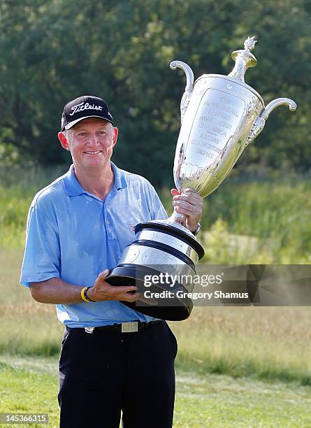 Roger Chapman of England holds up the Alfred S. Bourne Trophy after winning the 2012 Senior PGA Championship with a winning score of -13 at the Golf...