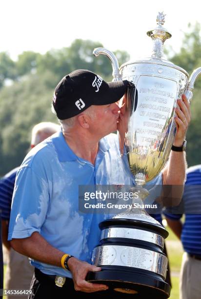Roger Chapman of England kisses the Alfred S. Bourne Trophy after winning the 2012 Senior PGA Championship with a winning score of -13 at the Golf...