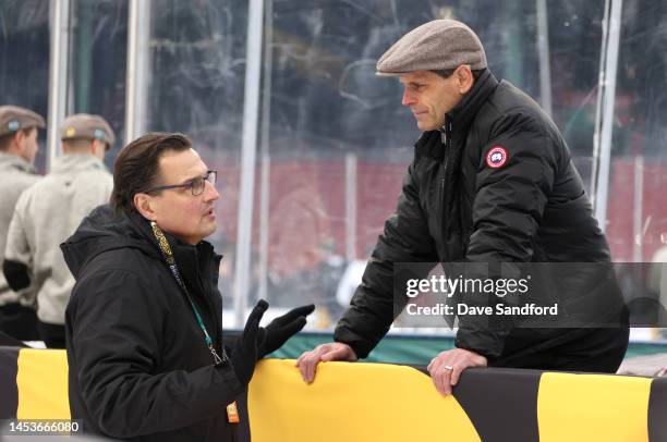 Ed Olczyk speaks with General Manager Don Sweeney of the Boston Bruins during a practice for the NHL Winter Classic at Fenway Park on January 01,...