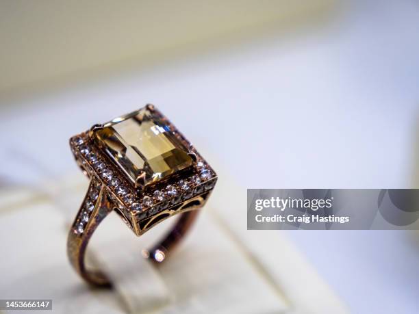 macro close up amber coloured gemstone set rings arranged in a row in jewellery store shop setting. luxury ring display with shining colourful stones and diamonds. high end luxury shopping. - joia - fotografias e filmes do acervo